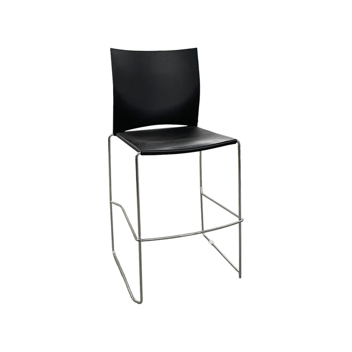 Black Xpresso stacking bar stool with metal legs, and footrest, from the side.