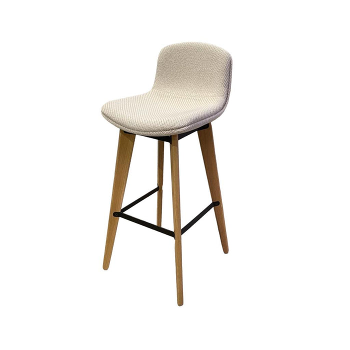 Cream bar stool with knitted upholstery and wooden legs, on an angle.